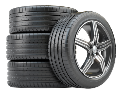 Five black car tires; one mounted on a silver and black rim, stacked beside the others.